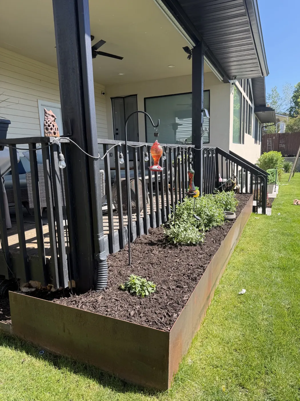 Steel-edged planting bed along a back deck